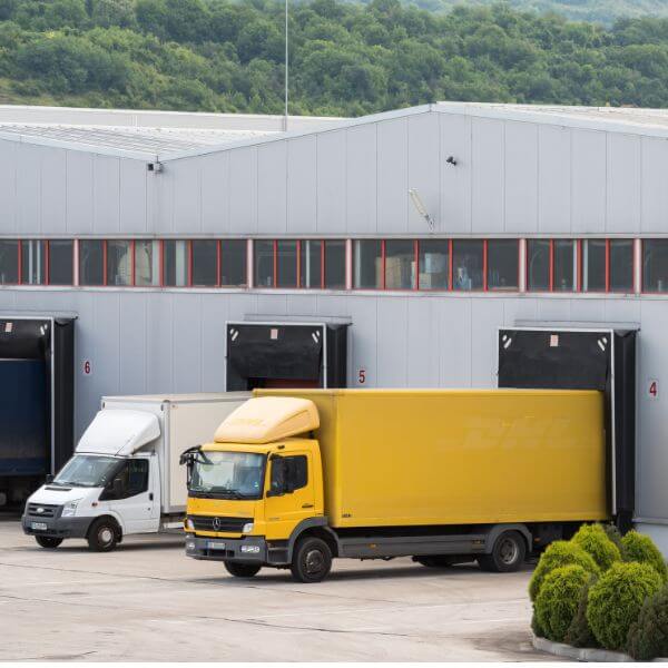 trucks unloading into warehouse dock