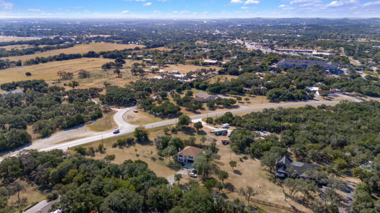 Aerial view of unrestricted land and surrounding development in the Texas Hill Country near Boerne Texas showing roads, acreage, and growth patterns.